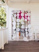 Curtain of doilies on strings on wooden veranda