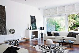 Elegant living room with light sofa, zebra skin and patio door