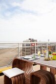 Designer outdoor furniture on balcony of penthouse apartment with view of North Sea beach