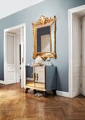 Opulent, Baroque mirror combined with mirrored, Art Deco cabinet in hallway of stylish, Viennese period apartment