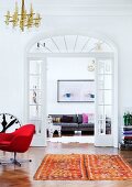 Mit verglasten Flügeltüren verbundene Altbauzimmer in der Wohnung eines Liebhabers von Kunst, zeitgenössischem Design und Retro Möbeln