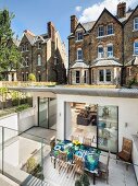 Modern extension of Victorian country house with green roof, sunken living area and terrace with glass balustrade