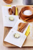 Wooden cutlery in lovingly made paper cutlery bags decorated with flattened bottle tops and flower motifs