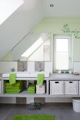 Children's attic bathroom - washstand on pale grey structure with storage, pastel green wall and message written next to narrow window