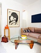 Classic coffee table on flokati rug and leather couch in corner; portrait of woman on wall