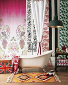 Badtraum - Folkloristischer Teppichläufer vor Vintage-Badewanne, an Wand verschiedene Tapetenbahnen mit Muster