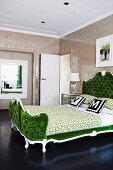 Grünes Doppelbett mit gepolstertem Kopfteil im Neo-Rokokostil vor tapezierter Wand in elegantem Ambiente