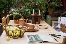 Basket of apples and rustic coffee service on wooden table