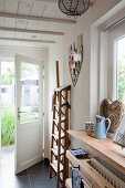 Holzleiter mit breiten Stufen im Hausflur mit offener Tür
