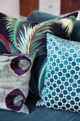 Various scatter cushions with patterns of geometric shapes and plant motifs on sofa