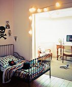 Retro Metall Gitterbett im Jugendzimmer, vor breitem Durchgang mit Lampions dekoriert, Blick in traditionelle Loungeecke