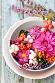 Autumnal arrangement of flowers & berries in bowl