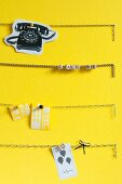 Chains used as pinboard on yellow wall