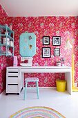 Modern, white desk and wallpaper with floral pattern on pink background in nostalgic, child's bedroom