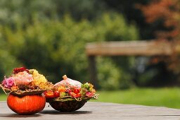 Autumnal flower arrangements in hollowed-out pumpkins outdoors