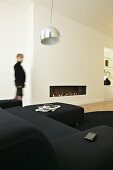 White living room with black sofa set and fireplace integrated into wall