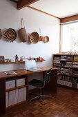 Home office in corner with collection of baskets hanging on wall