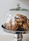 Kekse auf silberner Tortenplatte mit Glashaube