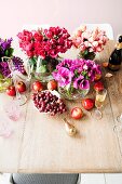 Vases of flowers and fruit on simple wooden table