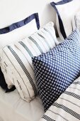 Double bed with blue and white pillows in different patterns