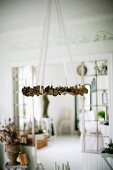 Wreath suspended from ceiling on white ribbons in rustic interior