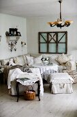 Cosy, rustic lounge area with armchairs, ottomans and corner sofa around coffee table