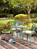 Ornate bistro table and turquoise chairs on rustic terrace seating area