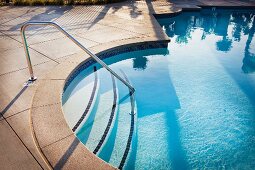 Kreisförmiger Einstieg in Pool mit Edelstahl Geländer auf Treppe