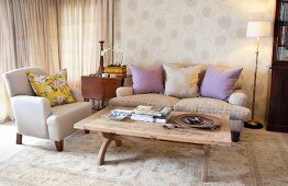 Pale beige sofa set with scatter cushions and floral wallpaper in delicate, shabby-chic lilac