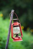 Vintage storm lamp attached to metal rod in garden
