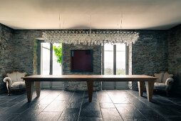 Chandelier made from 200 stemware glasses above long dining table in salon of Italian farmhouse