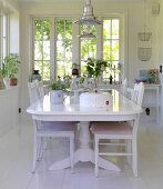 Weisser Esstisch und Stühle auf weißem Dielenboden im Esszimmer