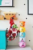 Stacking toys and train-shaped coat rack on white wall with black polka dots