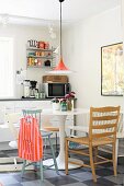 Danish, classic Semi lamp above Tulip table and mixture of chairs in youthful, retro kitchen-dining room