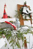 Festive arrangement with Welcome sign outside house with figurines, lanterns, ice skates and fir branches