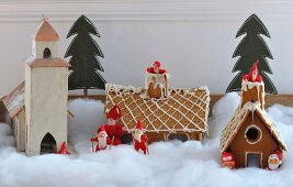 Holzmodell einer schwedischen Kirche, Lebkuchenhäuser und Nikolausfiguren in Dekoschnee