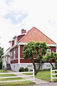 Vorgarten eines traditionellen, schwedischen Wohnhauses mit rot und weiss gestrichenen Holzelementen