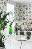 Indoor palm in living room with fern-patterned wallpaper