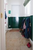 Cloakroom with lower half of walls and door painted glossy dark green