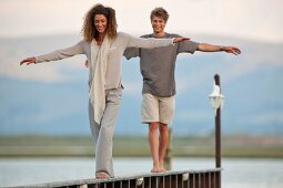 Young couple balancing on railing