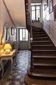 Foyer in historical house with lamp on console table and staircase
