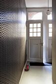 Foyer with geometric wallpaper and open front door