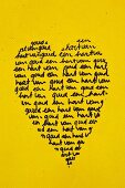 Heart-shaped, Norwegian text art on yellow-painted door