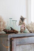 Vasen, Glasbehälter und Fundstücke aus dem Meer auf altem Schrank im Badezimmer
