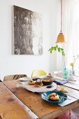 Rustic dining table in front of modern artwork on wall