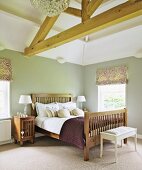 Double bed with wooden slatted headboard and foot in rustic bedroom