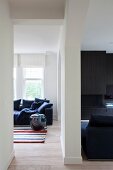 View of blue sofa in front of window in open-plan interior