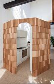 Designer kitchen in cabin clad in cedar shingles in high-ceilinged interior