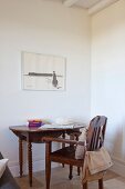 Antiker Stuhl und Tisch, darüber Zeichnung an Wand, in schlichter Zimmerecke