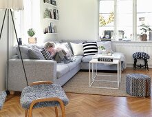Young children sitting on grey sofa in modern living room with Scandinavian ambiance